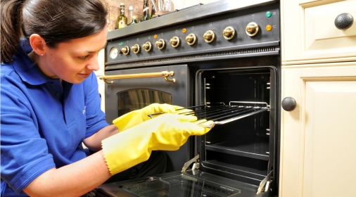 A ovenclean specialist putting an oven rack into the oven